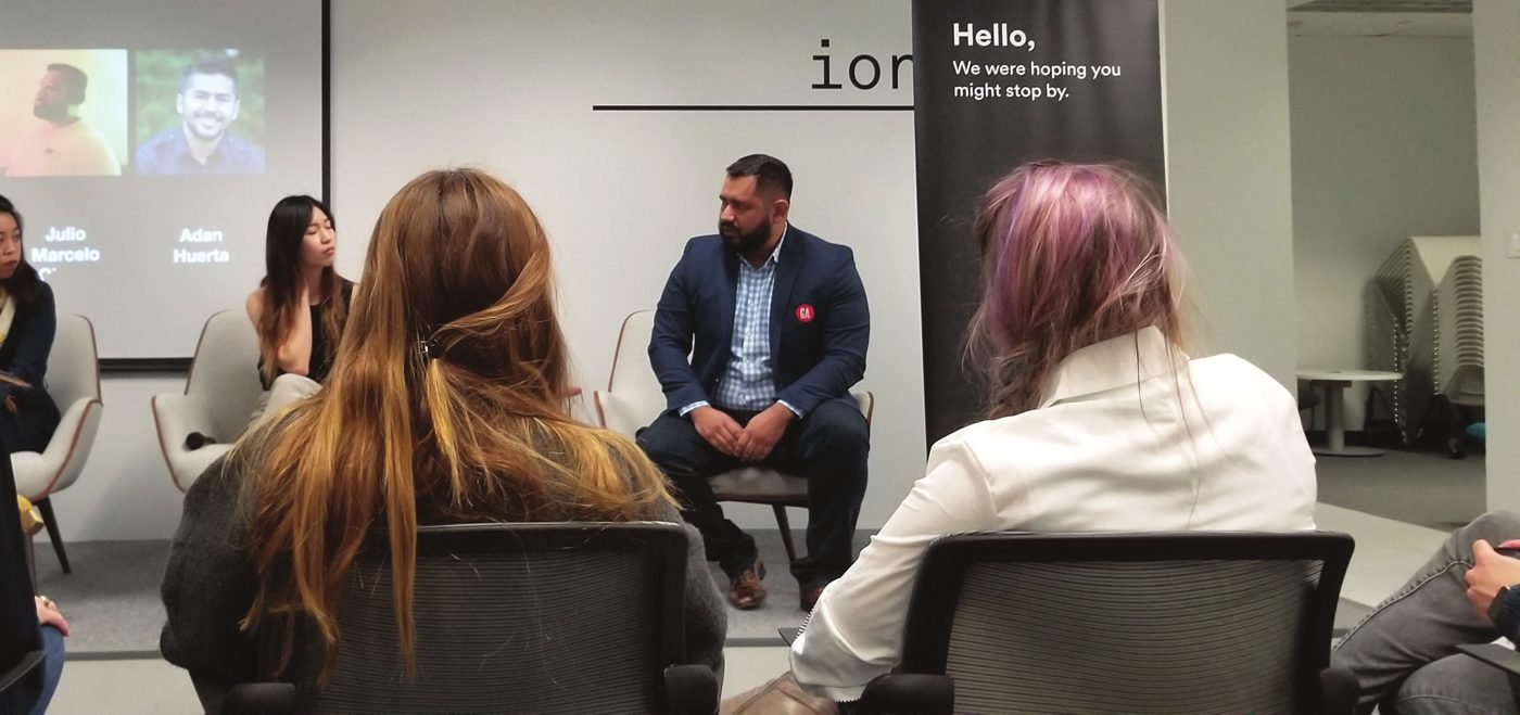 Marcelo seated on an expert panel in front of an audience